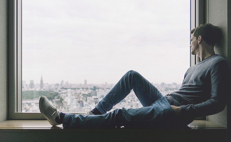A férfi egy ablakban ül és kifelé néz