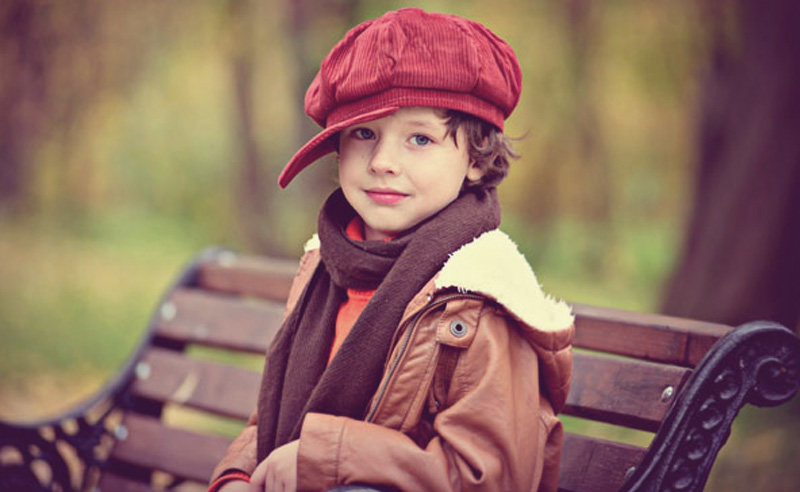 Piros sapkás fiú a padon