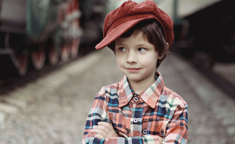 Piros sapkás fiú régi vonatok között