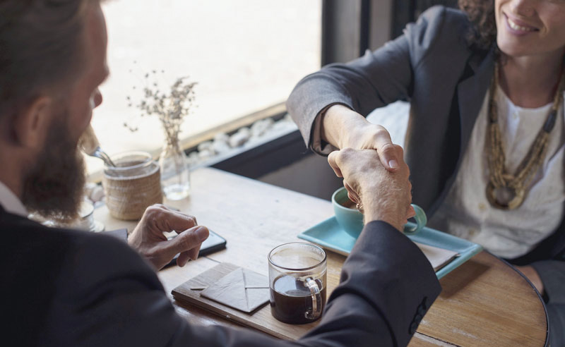 Kézfogás - kávézóasztalnál